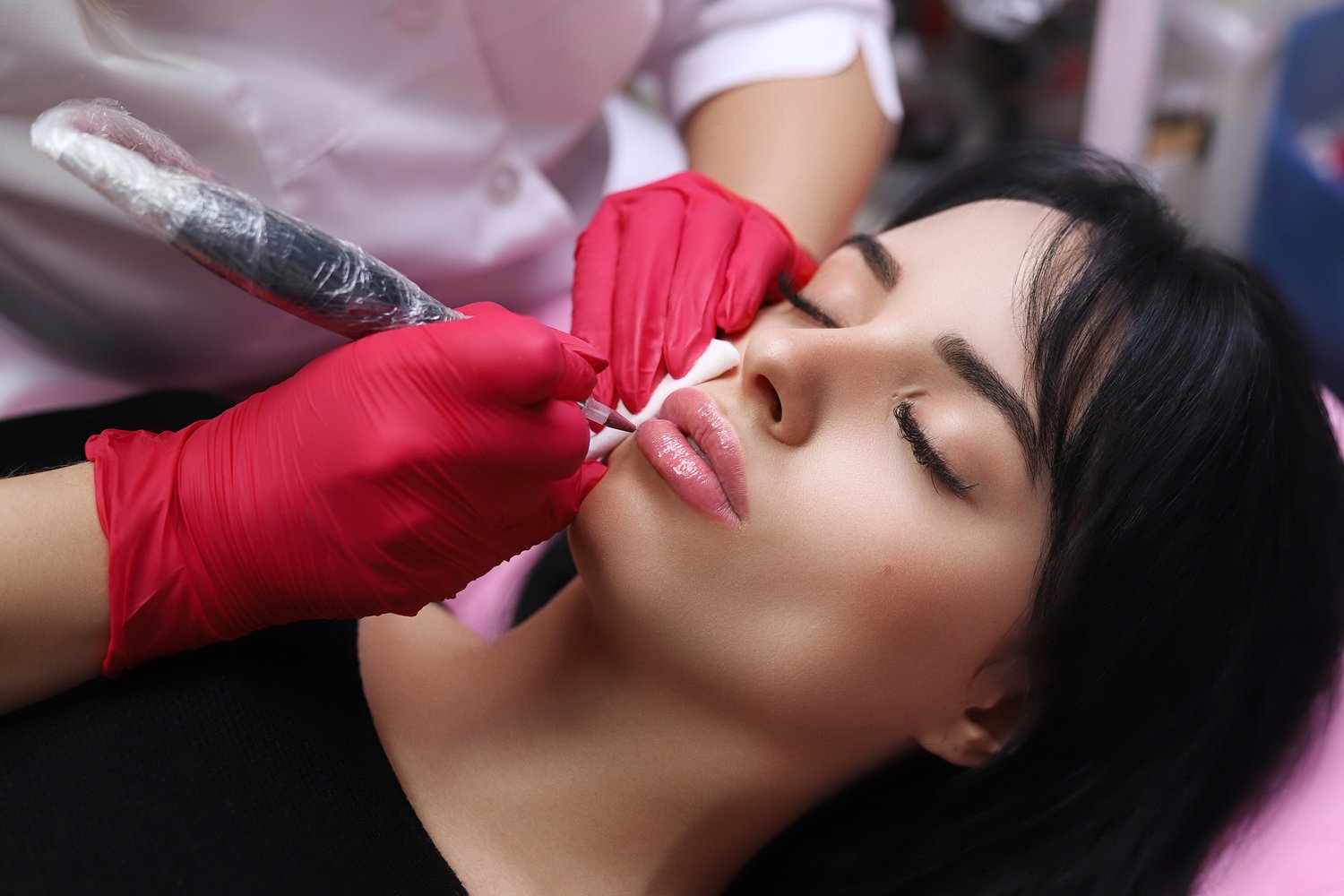Healthy Spa: Young Beautiful Woman Having Permanent Make-up (Tattoo) on her Lips. Close-up